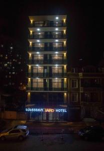 a tall building with a hotel sign in front of it at HOTEL LORD in Batumi