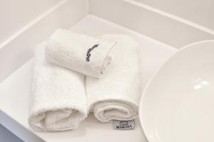 ein paar Handtücher auf einer Toilette in der Unterkunft Casa Mimosa Hotel in Izmir