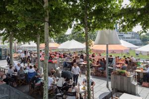 
a patio area with tables, chairs and umbrellas at Hotel New York in Rotterdam
