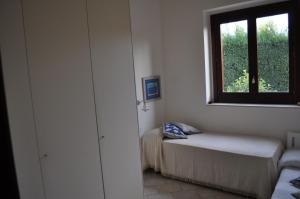 ドンナルカータにあるVilla degli Oliviのベッドと窓が備わる小さな客室です。