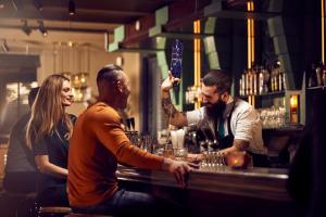 a group of people sitting at a bar at Hotel New York by WestCord in Rotterdam
