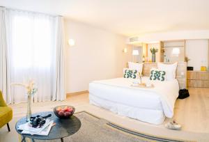 a bedroom with a large white bed and a table at Château L'Hospitalet Wine Resort Beach & Spa in Narbonne