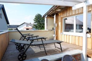 Brockscheid的住宿－Ferienunterkunft Vulkaneifel - Baltes-Haus，坐在甲板上的一排椅子