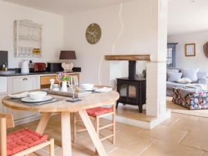a kitchen and living room with a table and a stove at Apple Store Cottage in Charlbury