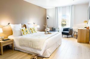 a bedroom with a large white bed and a desk at Château L'Hospitalet Wine Resort Beach & Spa in Narbonne