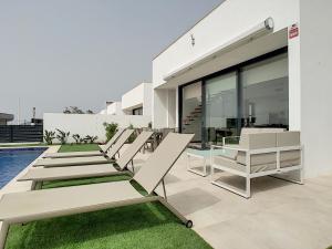 a row of lounge chairs sitting on the side of a building at Villas Alamos - 4509 in Mar de Cristal