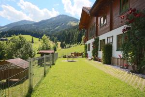 a house with a fence next to a grass yard at Haus Diamant by Schladming-Appartements in Schladming