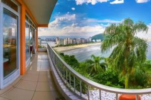 a balcony with a view of the ocean and palm trees at Ilha Porchat - Loft Vista Incrível in São Vicente
