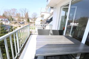 eine Holzterrasse mit Stühlen auf dem Balkon in der Unterkunft Ferienwohnung Ostseebrise in Baabe