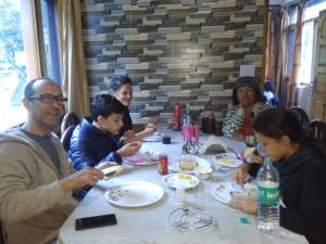 een groep mensen die rond een tafel eten bij The Heritage, Sarahan in Sarāhan