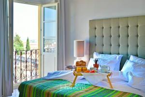 a bed with a table with a bowl of fruit on it at Noble House Essence Évora - by Unlock Hotels in Évora +78 photos