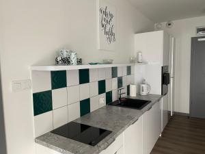 a kitchen with white and green tiles on the wall at Morze, Basen&SPA i Spokój Apartament Pięć Mórz w Sianożętach in Sianozety