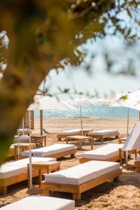a row of beach chairs sitting on top of a sandy beach at Château L'Hospitalet Wine Resort Beach & Spa in Narbonne