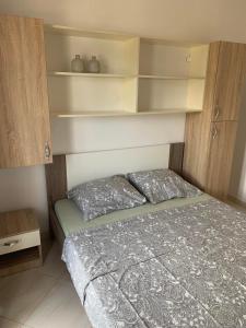 a small bedroom with a bed and shelves at Apartments Nurkovic in Dobra Voda