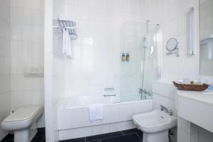 a white bathroom with a sink and a toilet at Hotel Du Parc - Mulhouse Centre in Mulhouse
