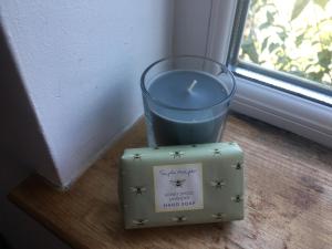 a candle sitting on a table next to a window at Driftwood Loft in Killyleagh