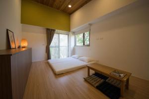 a room with a bed and a table and a window at 南窩綠丘-綠丘行旅-2萬坪庭園 in Tongxiao +16 photos