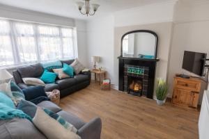 a living room with a couch and a fireplace at 'Sandy Bottom' Broadstairs by the beach in Broadstairs