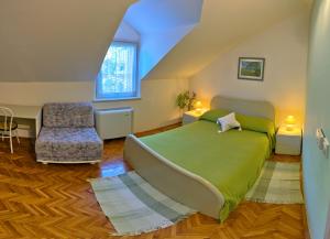 a bedroom with a green bed and a chair at Villa Šoulavy in Kaštela