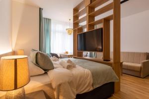 a bedroom with a large bed and a television at Apartmoon in Sarajevo