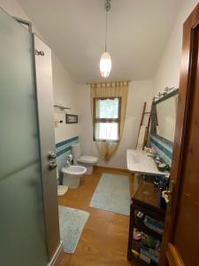 bagno con lavandino, servizi igienici e specchio di Casa ai Poggi dell'Argentario a Orbetello