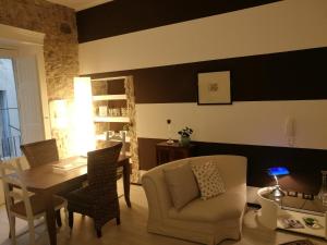a living room with a table and a couch and a chair at Al Campanile in Piazza Armerina
