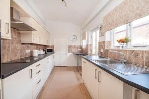 a large kitchen with white cabinets and a sink at 17 Penleys Grove Street in York