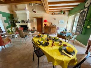 a dining room with a table with a yellow table cloth at Le p'tit nid de Gabriel in Les Touches-de-Périgny