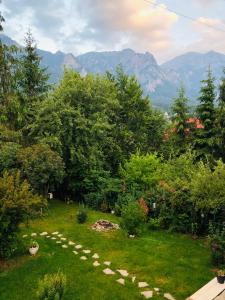a garden with a path in the grass with mountains at Bohemian Chalet in Buşteni