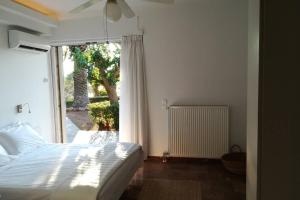 1 dormitorio con cama y ventana grande en Pine tree beachfront villa, en Drosiá