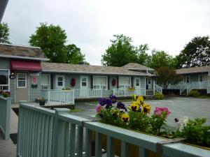 een rij huizen met bloemen op een hek bij Motel de l'Outlet in Magog-Orford