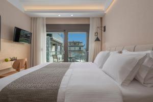 a bedroom with a large white bed and a balcony at ALPE LUXURY ACCOMMODATION Penelope Collection in Olympiada +97 photos