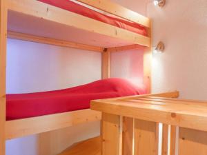 メリベルにあるAppartement Méribel, 3 pièces, 6 personnes - FR-1-182-181の赤い毛布が備わるドミトリールームの二段ベッド1台分です。