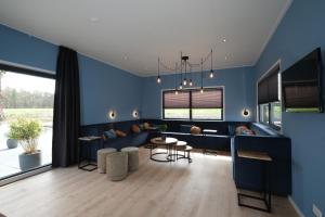 a living room with blue walls and a table and chairs at Hofparken Wiltershaar - groepsaccommodatie met privé wellness in Kotten