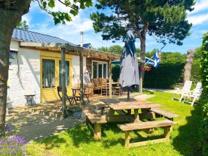 a picnic table and an umbrella in front of a cottage at Bungalow OK03 Burgvliet Oostkapelle in Oostkapelle