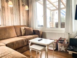 a living room with a couch and a table at Bungalow OK03 Burgvliet Oostkapelle in Oostkapelle