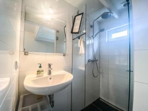 a bathroom with a sink and a shower at Bungalow OK03 Burgvliet Oostkapelle in Oostkapelle +10 photos