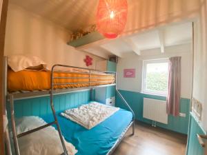 a bunk bed in a room with a blue wall at Bungalow OK03 Burgvliet Oostkapelle in Oostkapelle