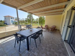 a patio with a wooden table and chairs on a deck at Xi House in Xi