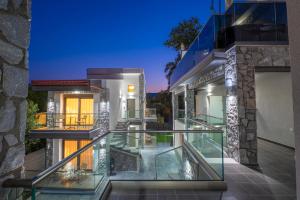 an image of a house with a glass balcony at ALPE LUXURY ACCOMMODATION Penelope Collection in Olympiada