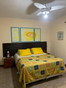 Un dormitorio con una cama con almohadas amarillas y un techo en Lindo Sobrado Amarelo -próximo a praia, en Mongaguá 87 fotos más