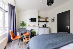 a bedroom with a large bed and a chair at Citystays Deventer in Deventer