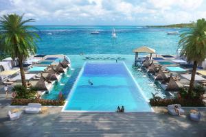 a swimming pool with umbrellas and the ocean at Sandals Royal Curacao All Inclusive Couples Only in Nieuwpoort