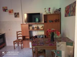 sala de estar con mesa y TV en Da Andrea & Viola, en Terralba