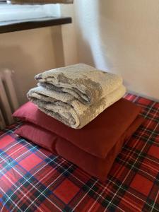 una pila di asciugamani appoggiata sopra un letto di Ski Paradise a Breuil-Cervinia