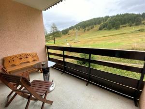 a balcony with a chair and a view of a field at Appartement Montgenèvre, 2 pièces, 4 personnes - FR-1-445-159 in Montgenèvre