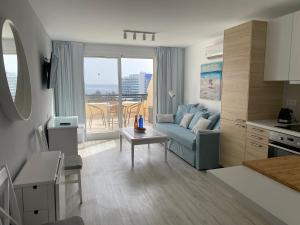 a living room with a blue couch and a table at Holamigos Morro Jable in Morro del Jable