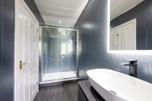 y baño con bañera blanca y ducha. en The Galley Of Lorne Inn, en Ardfern