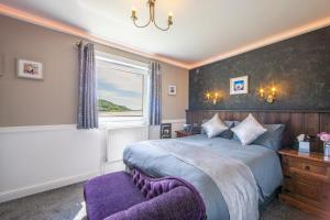 a bedroom with a large bed and a window at The Galley Of Lorne Inn in Ardfern