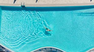 eine Person, die in einem großen Pool schwimmt in der Unterkunft Gloria Palace Amadores Thalasso & Hotel in Puerto Rico de Gran Canaria